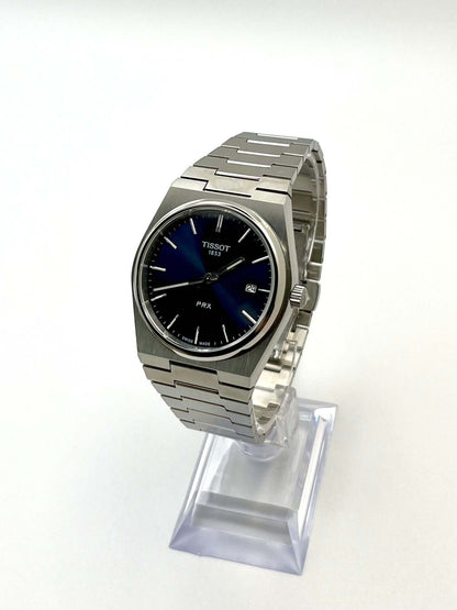 Tissot PRX Quartz T137.410.11.051.00 40mm stainless steel men’s watch with black dial, date display, sapphire crystal, and 100m water resistance